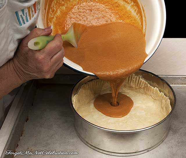 Pouring pumpkin filling into the crust